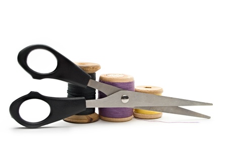 Thread bobbin and scissors on the white background の写真素材