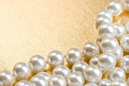 String of pearls on golden surfaceの写真素材