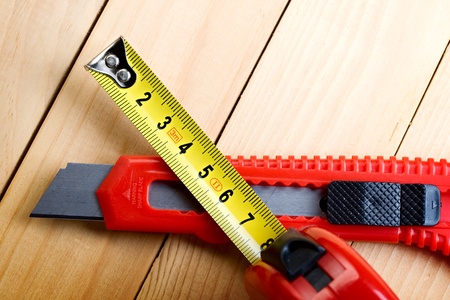 Tape measure and knife on wooden backgroundの写真素材