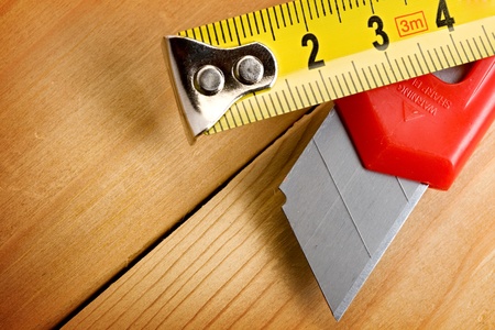 Tape measure and knife on wooden backgroundの写真素材