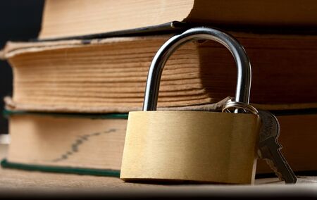 Pile of old books and keylockの写真素材
