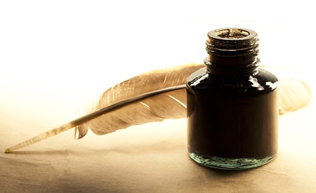 Feather and inkpot on paperの写真素材