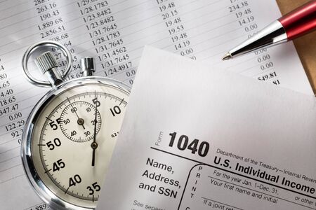 Tax form, operating budget and stopwatchの写真素材