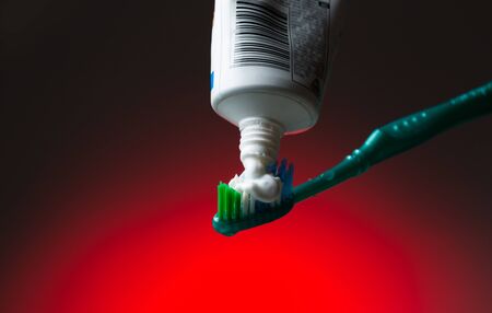 Toothbrush and toothpaste on redの写真素材