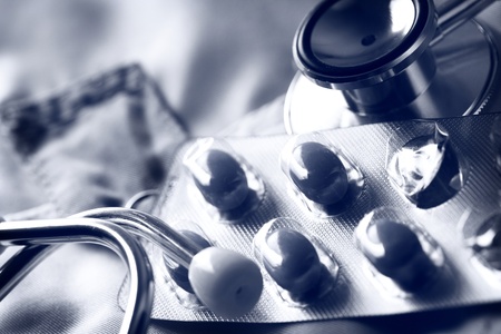 Stethoscope and pills and on doctor's smock の写真素材