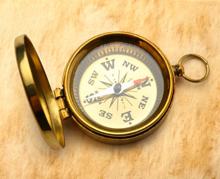 Golden compass on stained paper