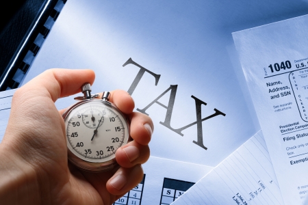 Operating budget, calendar, tax and stopwatch in handの写真素材