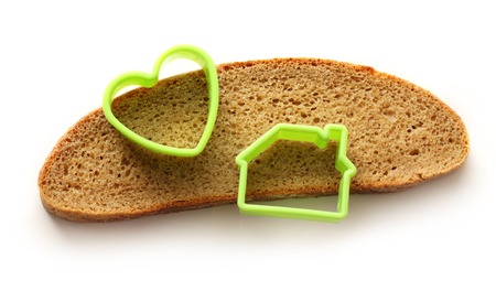 Slice of bread in house and heart form on white