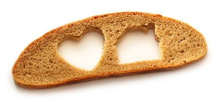 Slice of bread in house and heart form on white