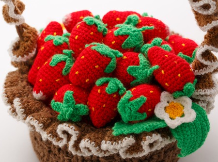Knitted strawberry in basket on whiteの写真素材