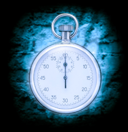 Stopwatch on cracked wall background in blue toningの写真素材