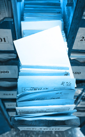 Paper documents stacked in archive on shelfの写真素材