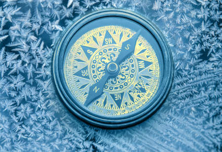 Vintage compass on snowflakes in blue toningの写真素材