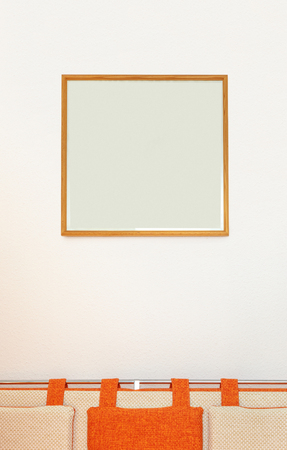 Cosy sofa with pillows and blank frame aboveの写真素材