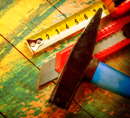 Tape measure, hammer and knife on wooden backgroundの写真素材