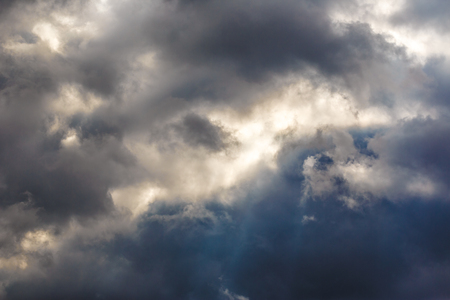 Dark clouds as background with sun raysの写真素材