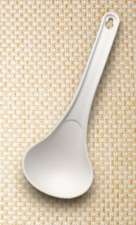 White plastic ladle on the cloth backgroundの写真素材