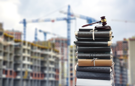 Document files with gavel on buildings under construction