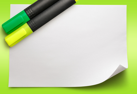Blank sheet of paper with markers on green backgroundの写真素材