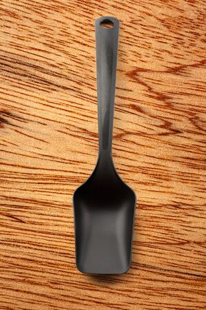 Black plastic kitchen spoon vertical in closeupの写真素材