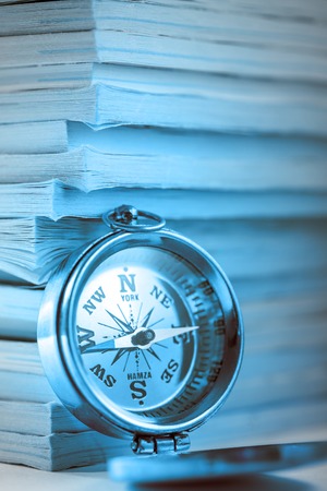 Stack of old magazines and golden compassの写真素材