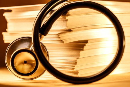Stethoscope and heap of paper cards in toning