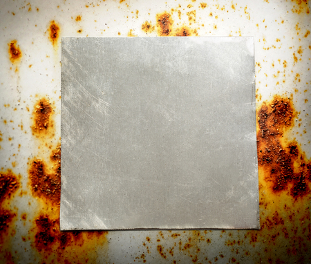 Blank square metal plate on rusty backgroundの写真素材