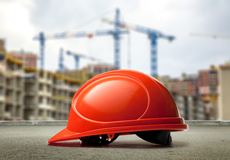 Red helmet on buildings and cranes backgroundの写真素材
