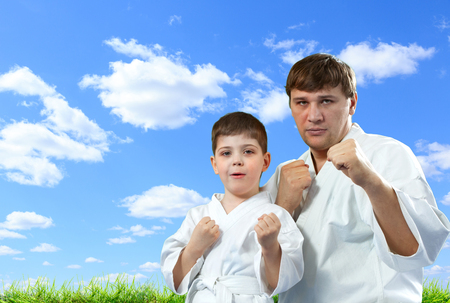 Karate master with his young student on blue sky backgroundの写真素材