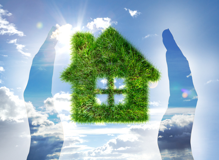 House made of grass on blue sky between handsの写真素材