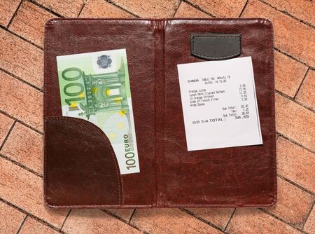 Open check folder with bill and euro banknotes
