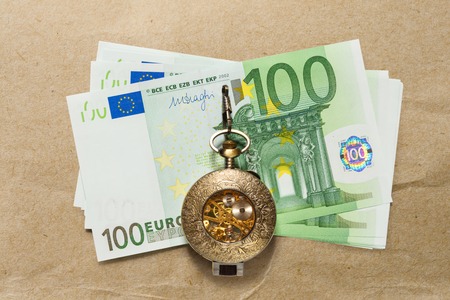 One hundred euro banknotes and vintage pocket watchの写真素材