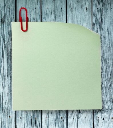 Green sticker and clip on wooden backgroundの写真素材