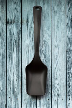 Black spoon on wooden panel background closeupの写真素材