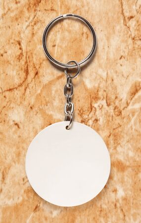 Key ring with round trinket on stone backgroundの写真素材