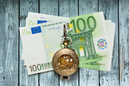 One hundred euro banknotes and vintage pocket watchの写真素材