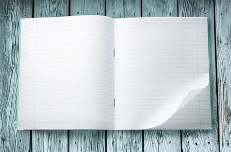 Opened notebook on the wooden background closeupの写真素材