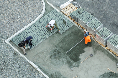 Workers constructing pavement with tile view from aboveの写真素材