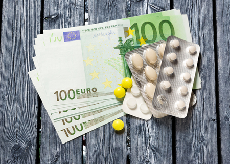 One hundred euro banknotes and pills closeupの写真素材