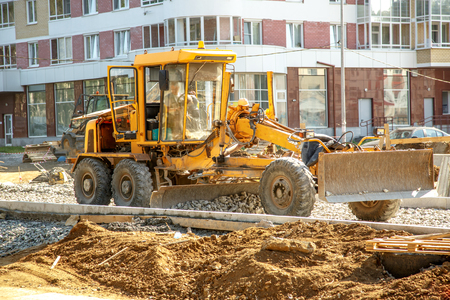 Grader working outside on road construction in summerの写真素材