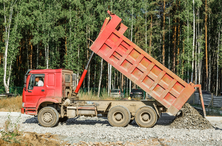 Tipper working outside on road construction in summerの写真素材