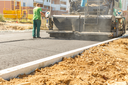 Asphalt-placing machine working on the city roadの写真素材