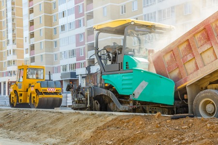 Asphalt-placing machine working on the city roadの写真素材