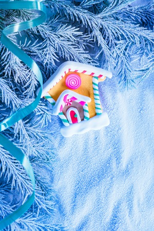 Christmas background with snow, firtree branch and houseの写真素材