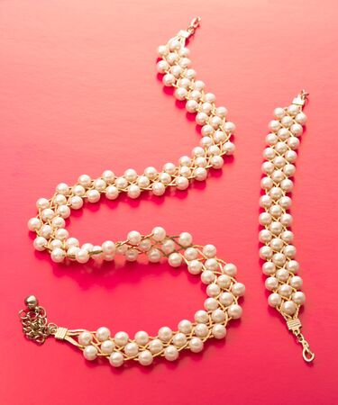 Necklace and wristband with golden chain and white beadsの写真素材