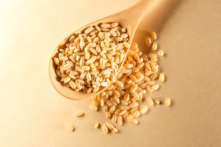 Pearl barley and wooden spoon in closeupの写真素材
