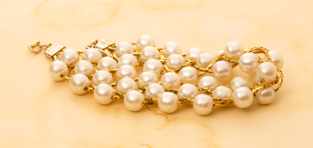 Wristband with golden chain and white beadsの写真素材