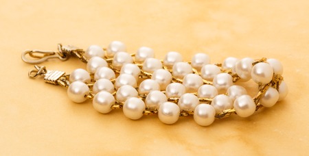 Wristband with golden chain and white beadsの写真素材