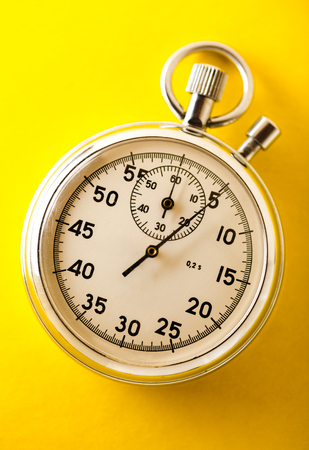 Stopwatch on yellow background in closeupの写真素材
