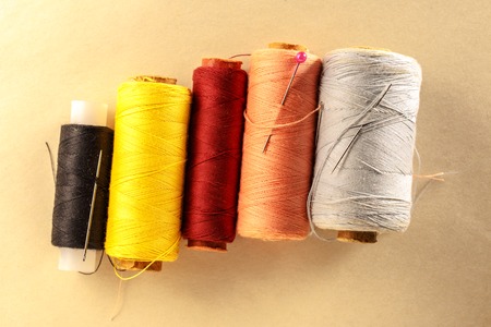 Thread bobbins and needles on paper backgroundの写真素材